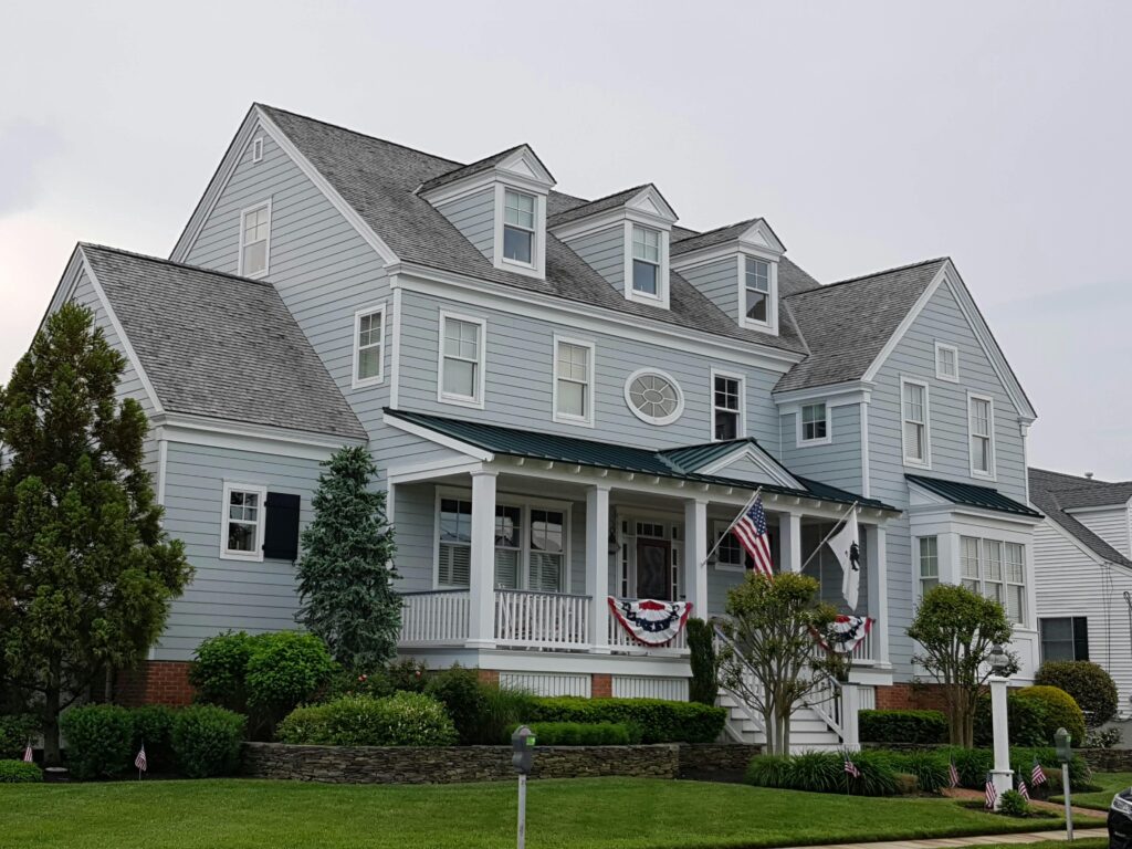 Elegant colonial-style house in Cape May, NJ with manicured lawn and American flags.
